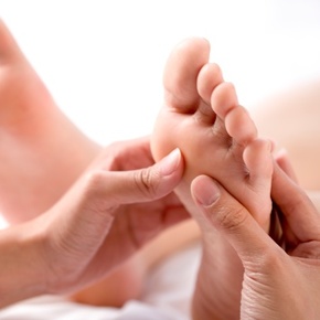 Young woman having feet massage (focus on feet)